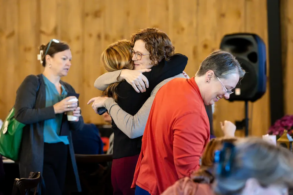 Two attendees hug between sessions