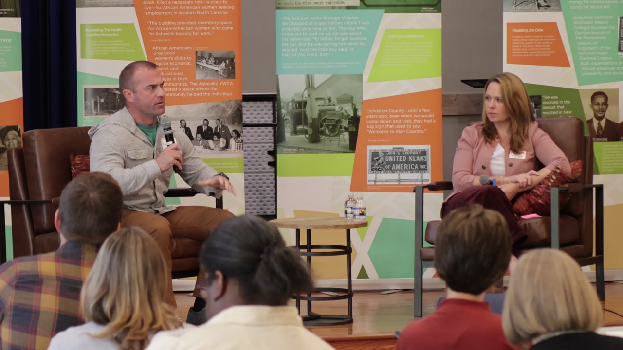 Keagan Monteith and Sarah Hankey in conversation on stage, the audience in the foreground.