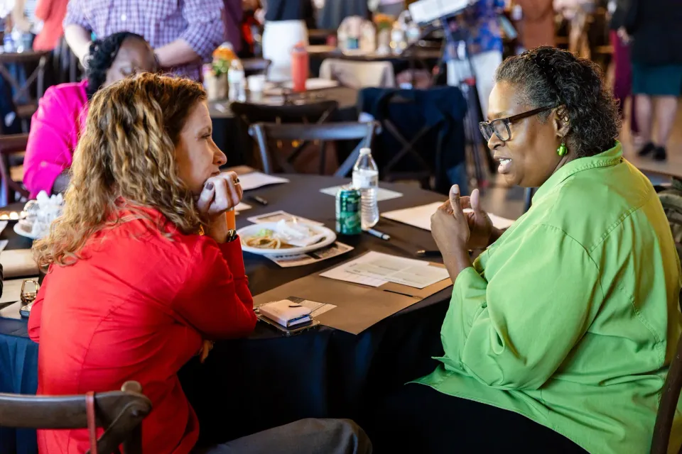 Convening attendees in conversation across a table at Deerwoode Reserve.