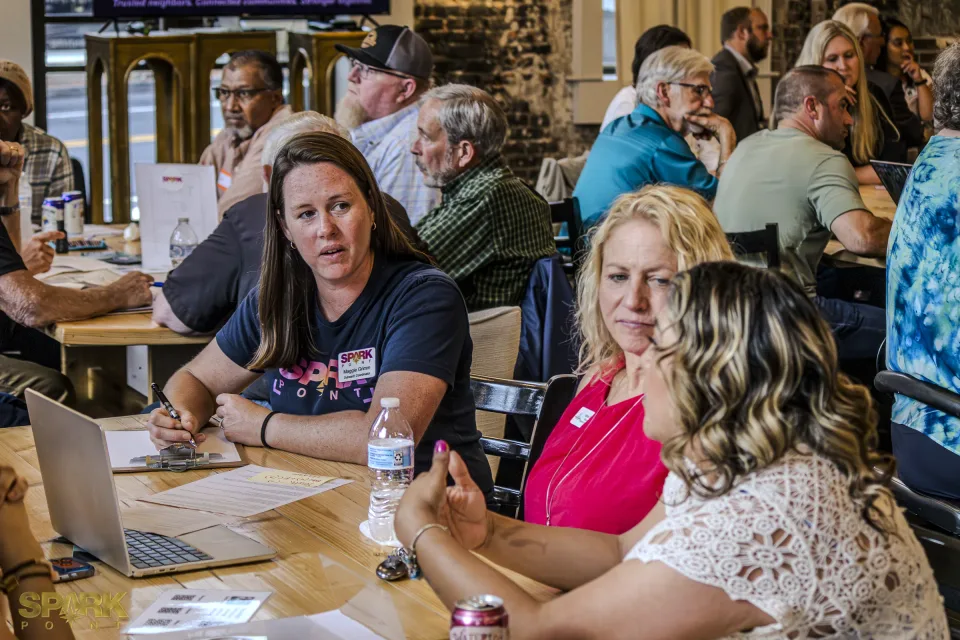 Community Connectors participants seated around tables during a facilitated listening session.